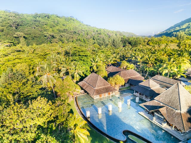 Luftbild des Hotels mit großem Pool umgeben von dichtem Wald