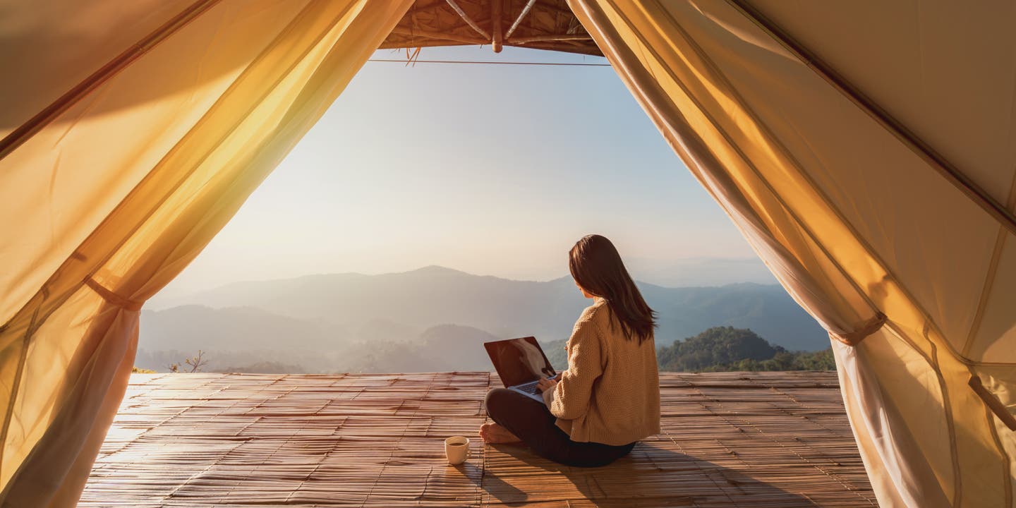 Frau arbeitet vor Bergkulisse