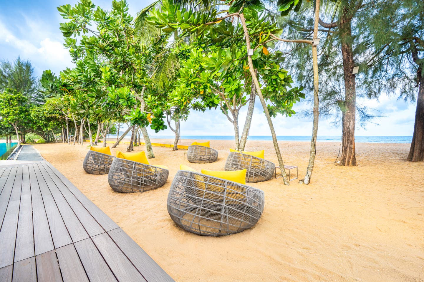 Lounge am Strand unter tropischen Bäumen