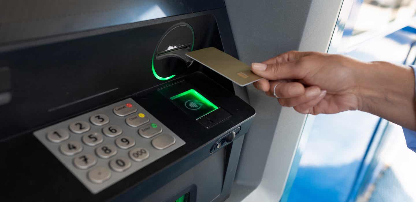 Kenias Währung: Weibliche Hand bedient einen Bankautomaten