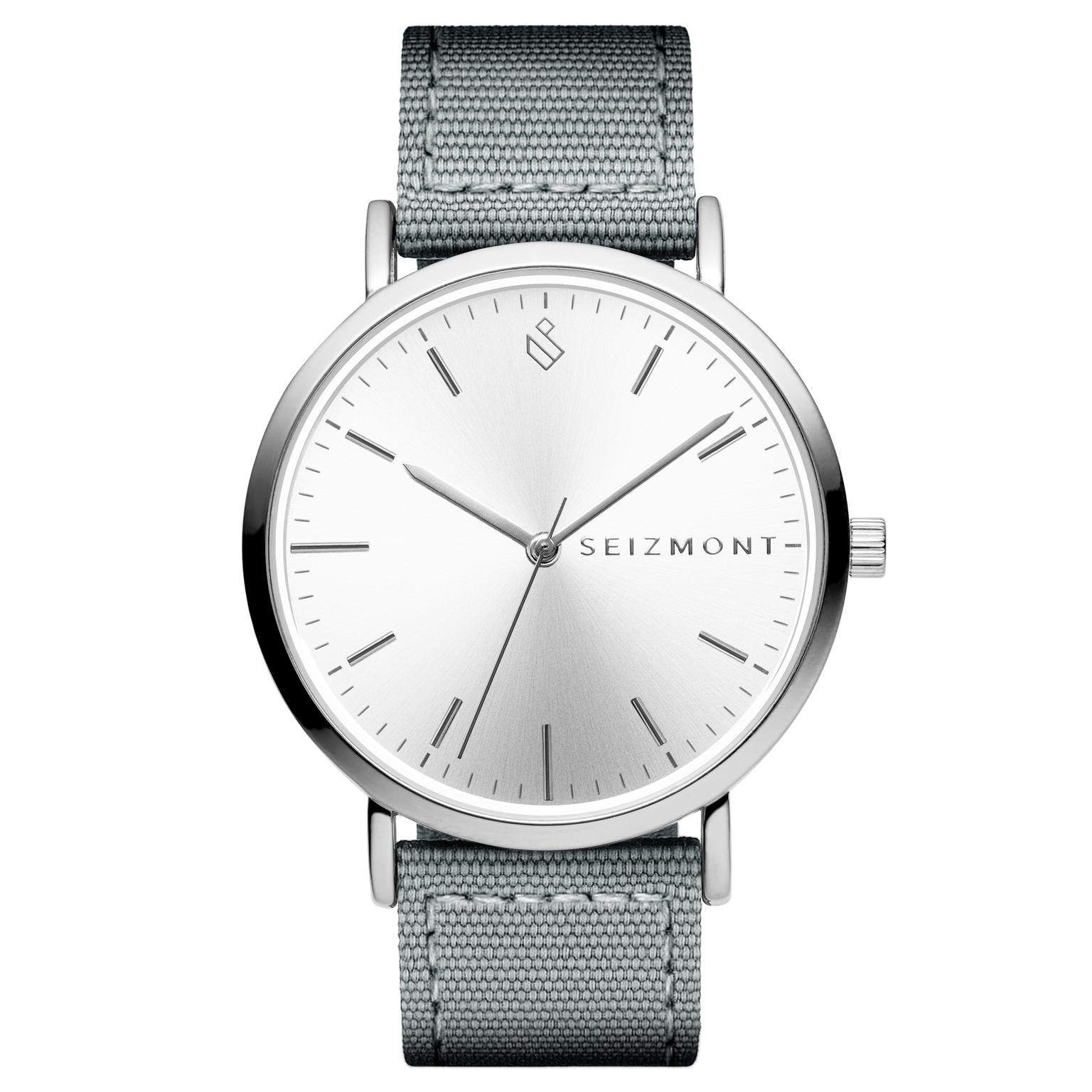 Moment | Sidabro spalvos minimalistinis elegantiškas analoginis kvarcinis laikrodis su sidabro spalvos ciferblatu ir tamsiai pilku nailoniniu dirželiu Moment | Sidabro spalvos minimalistinis elegantiškas analoginis kvarcinis laikrodis su sidabro spalvos ciferblatu ir tamsiai pilku nailoniniu dirželiu