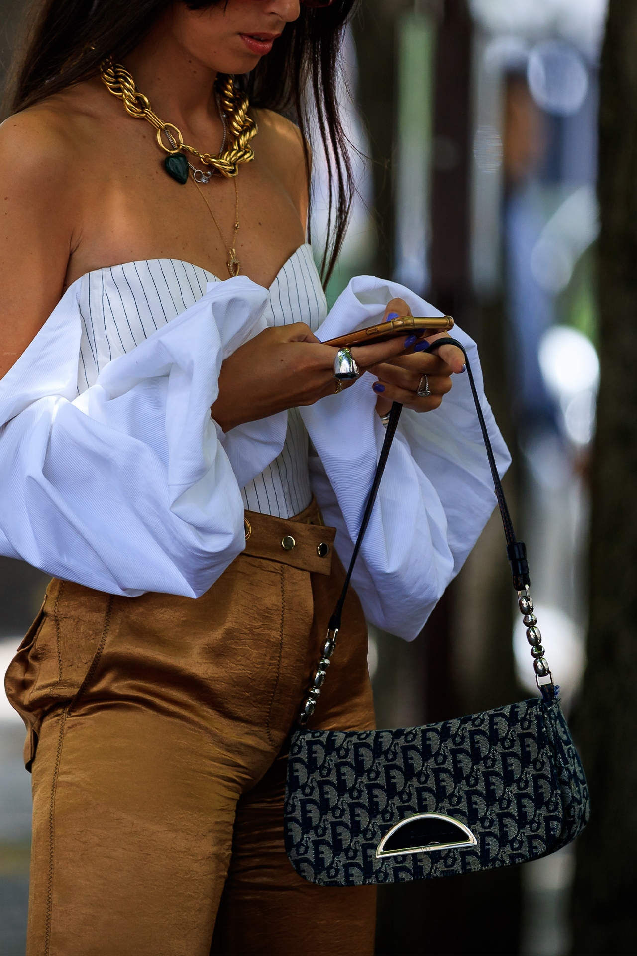 young woman with vintage dior bag looking at her phone