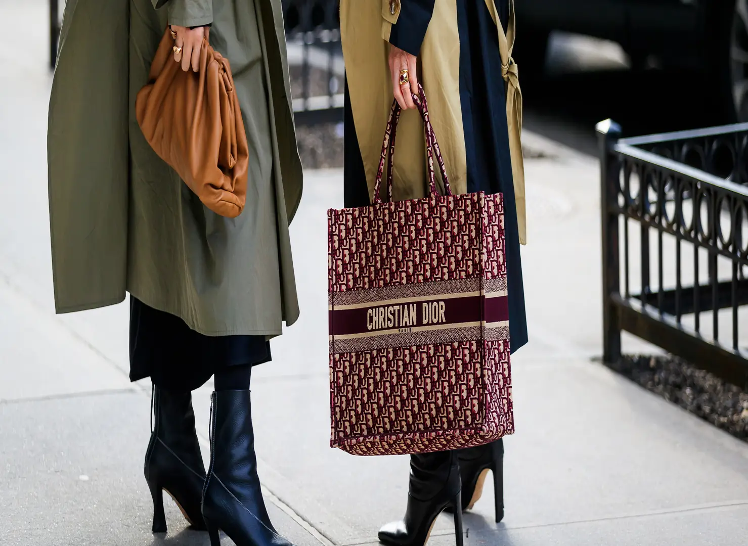 women-discussing-with-christian-dior-monogram-book-tote-bag-and-brown-bag-street-style.jpg