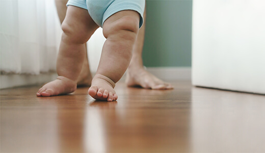 Juega conmigo. Adorable bebé arrastrándose en el suelo en casa, papá viendo a su hijo, copiando espacio