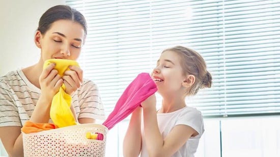 Mujer oliendo ropa limpia