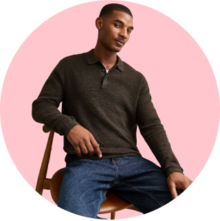A man wearing a brown knitwear and jeans.