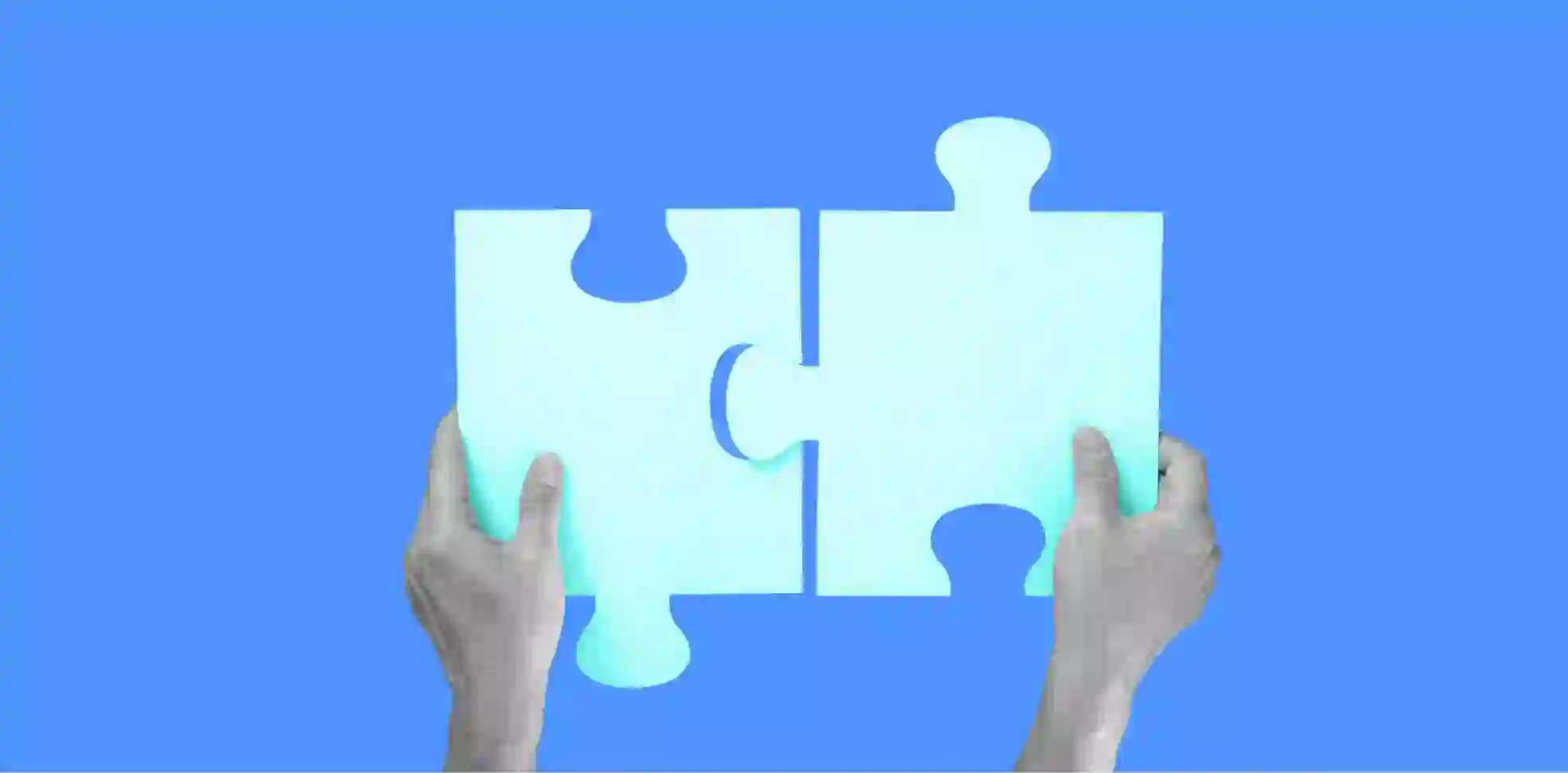 hands connect two puzzle pieces on blue background