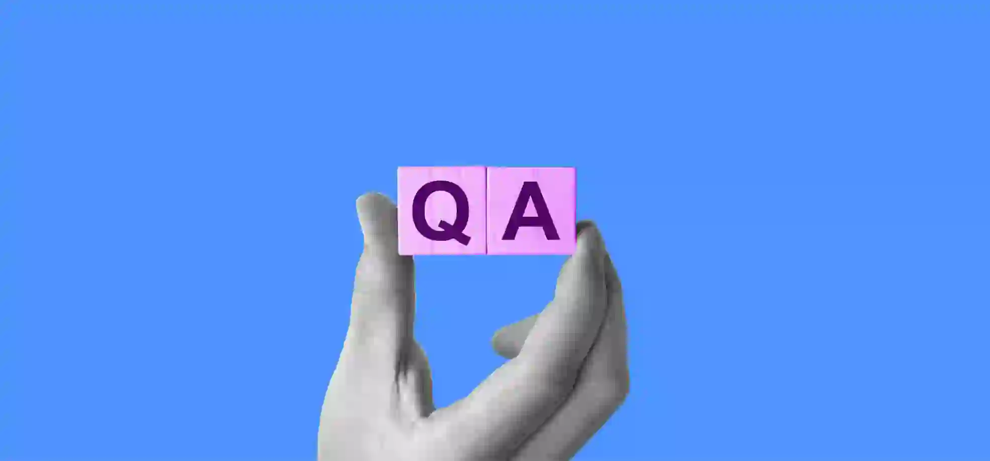 a hand holding cubes with letters Q and A