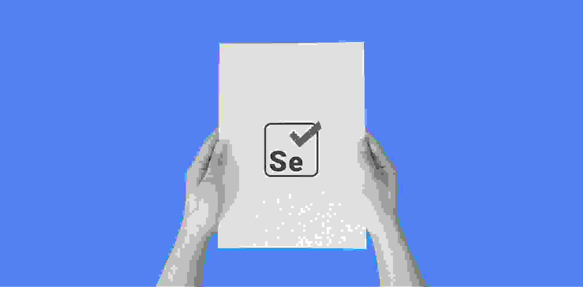 manos sosteniendo una hoja de papel con el logo de Selenium