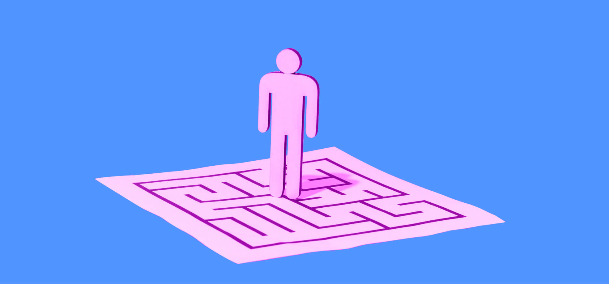 a human figure stands on a sheet of paper with a drawn labyrinth