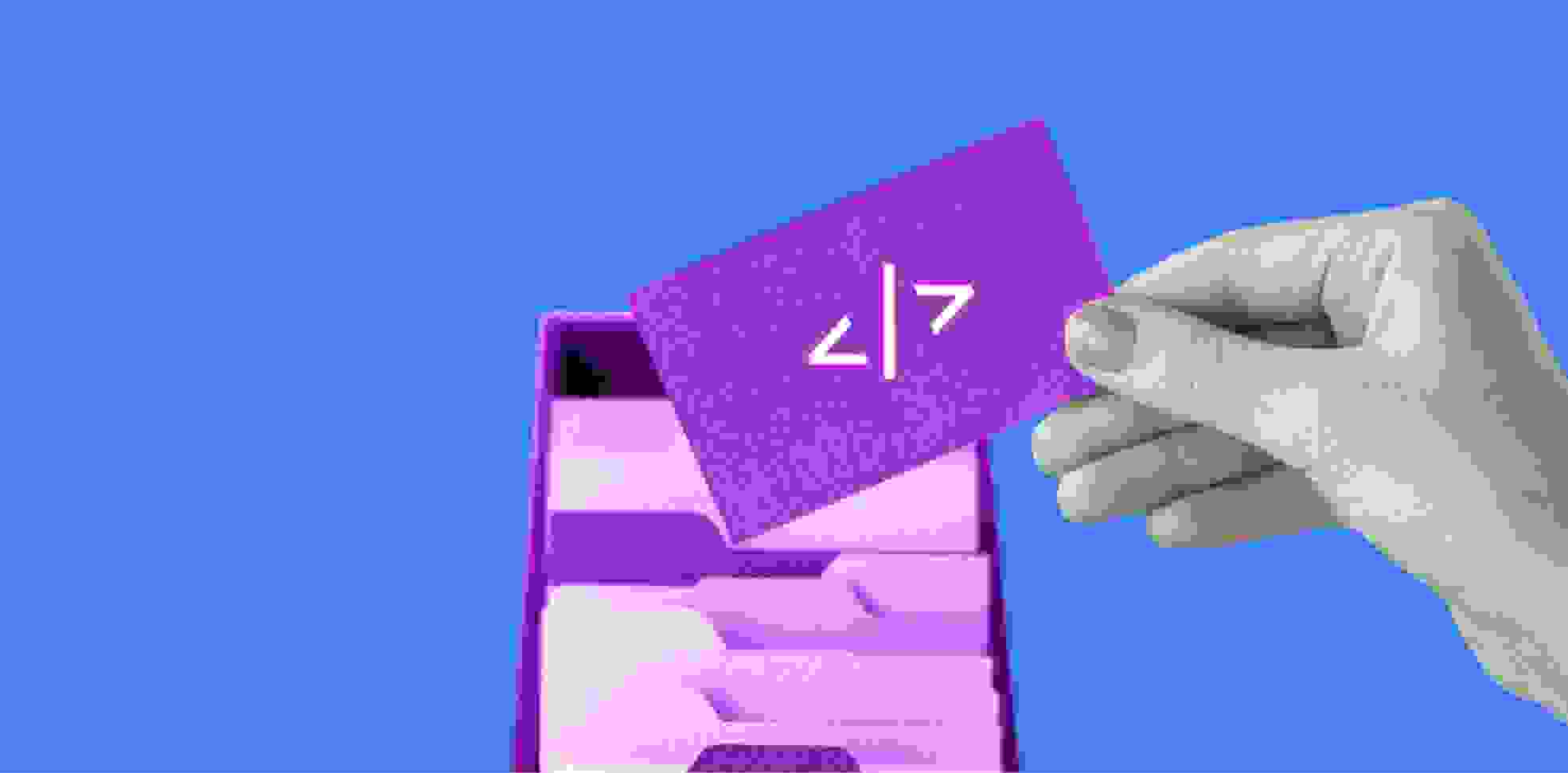 purple card in a hand and a filing cabinet box on blue background