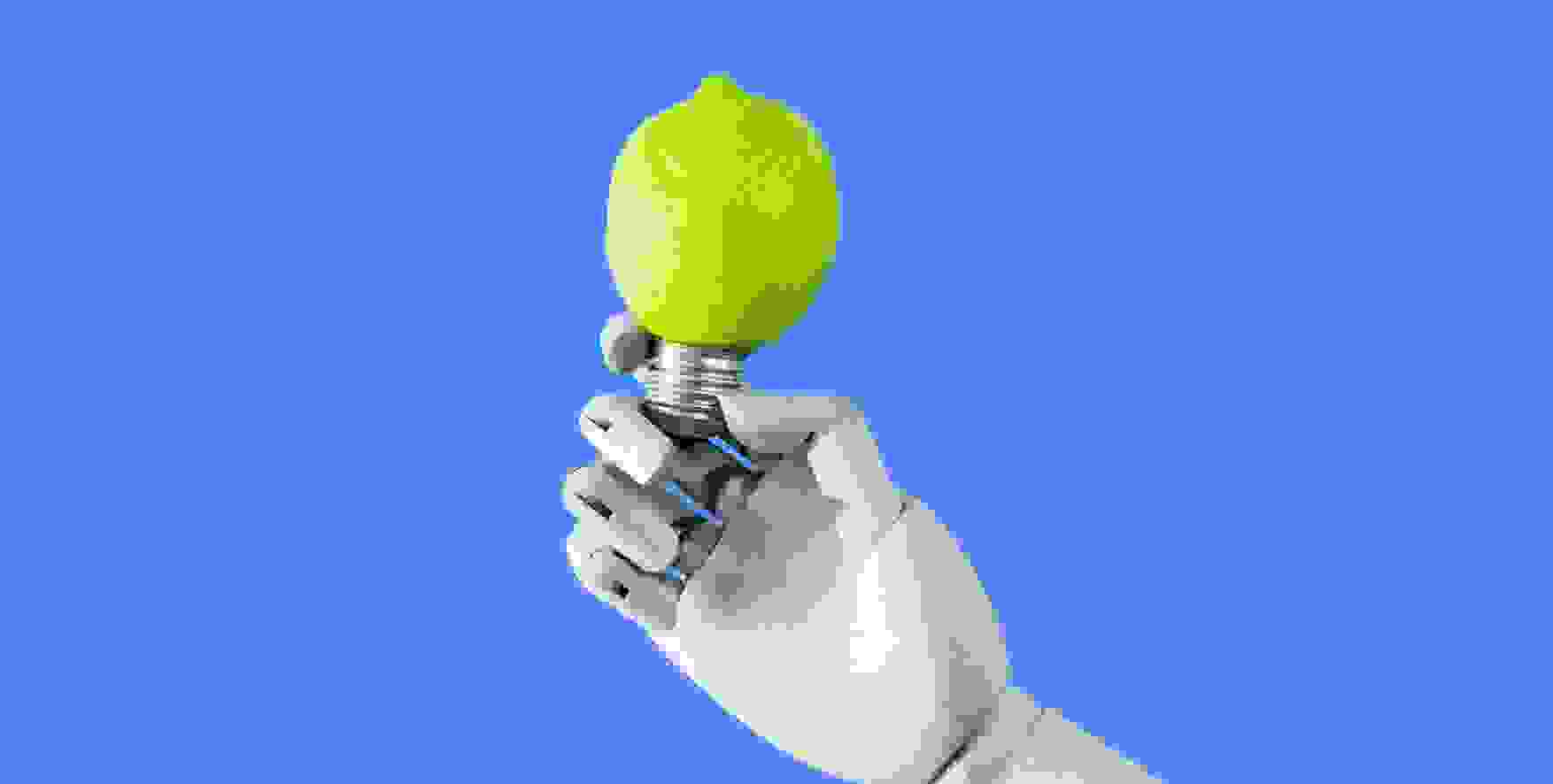a robot hand holding a light bulb in the shape of a lemon