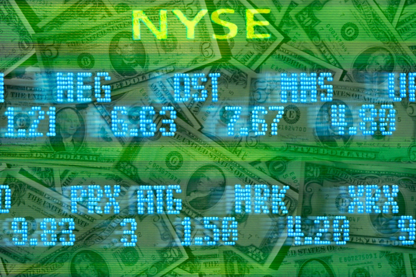New York Stock Exchange stock trading board listings moving across US dollar bills.