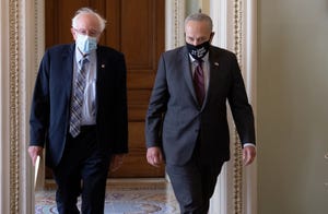 Sen. Bernie Sanders (L) (I-VT) walks with Senate Majority Leader Chuck Schumer (D-NY).