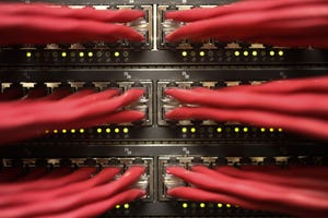 Red cables attach to servers in a data center cabinet rack.
