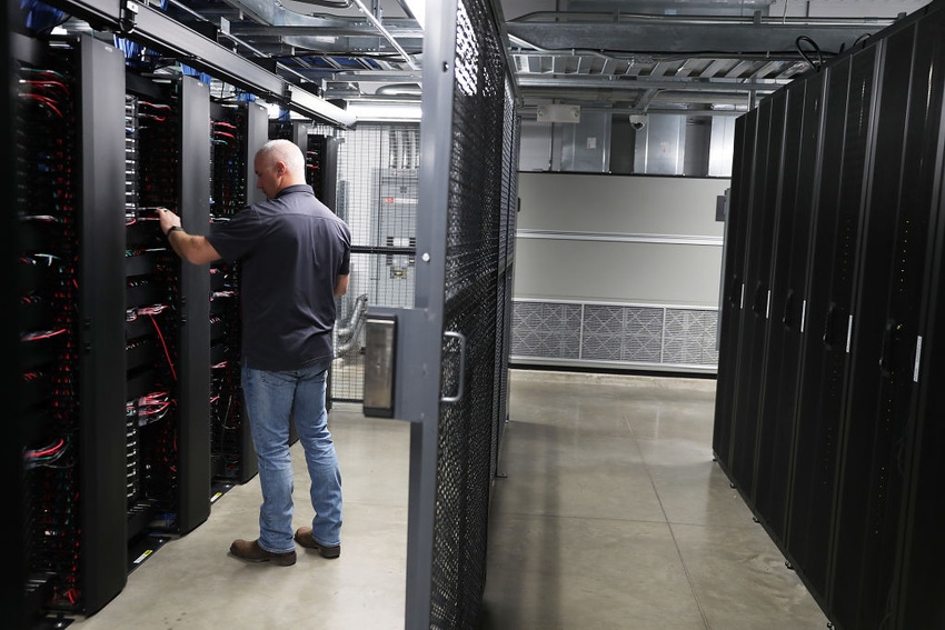 A staff member works among the racks and network switches in the data center of LightEdge Solutions in Altoona, Iowa.