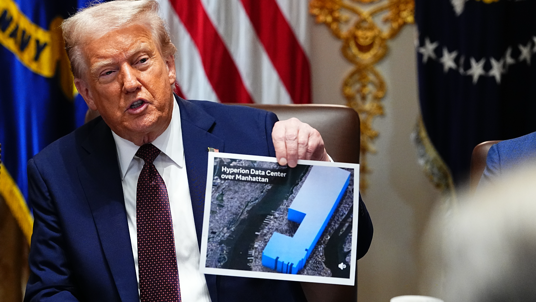 US President Donald Trump holds a graphic comparing the size of Meta's new “Hyperion” data center in rural Louisiana to Manhattan
