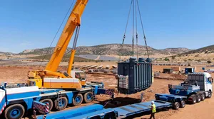 Crew uses a crane to install power transformers and control equipment Crew uses a crane to install power transformers and control equipment