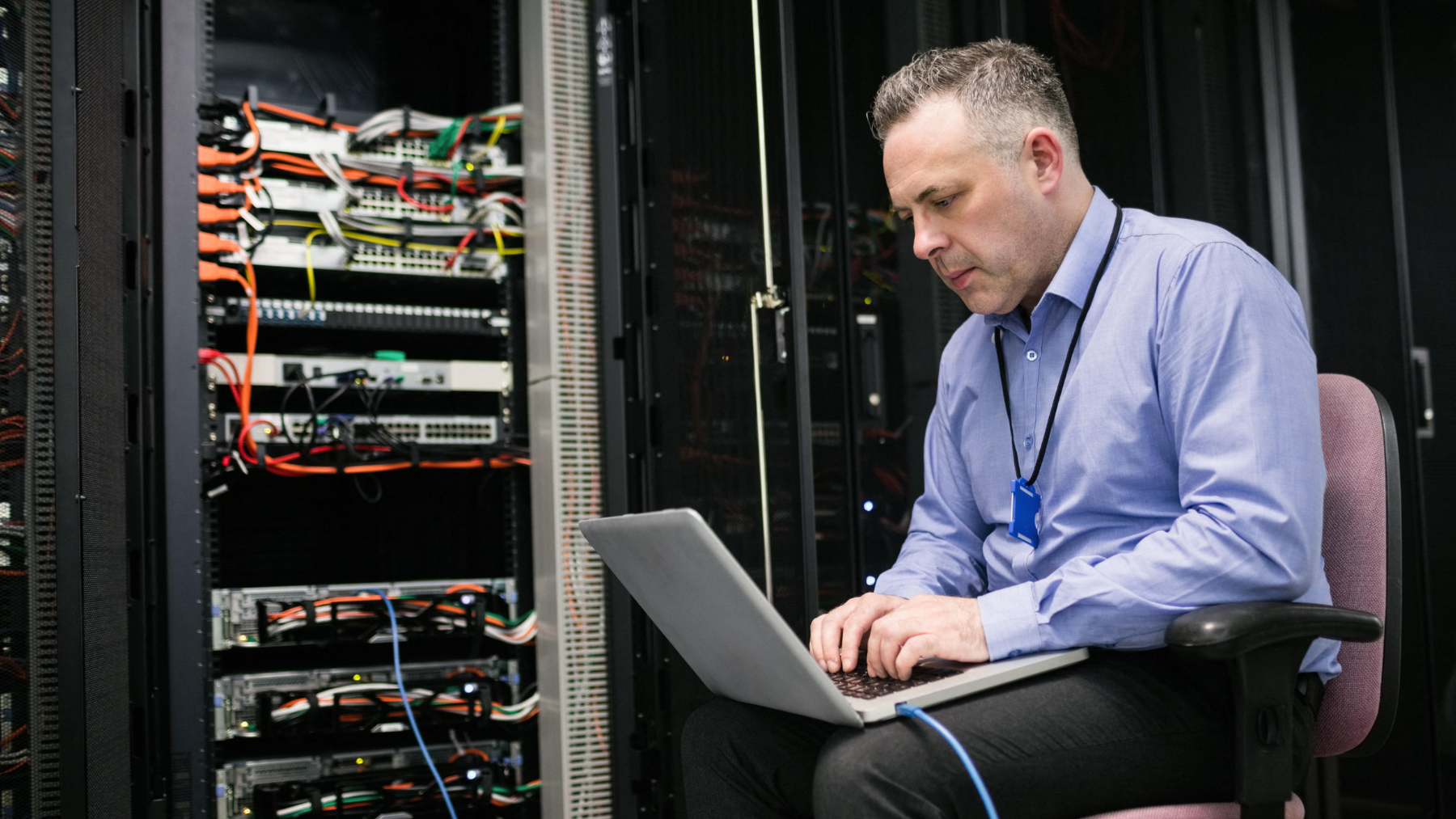 technician working on laptop in data center