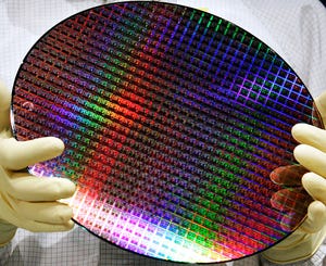 An assistant presents a dummy of a 300 millimeter wafer at AMD Advanced Micro Device on October 14, 2005 in Dresden, Germany