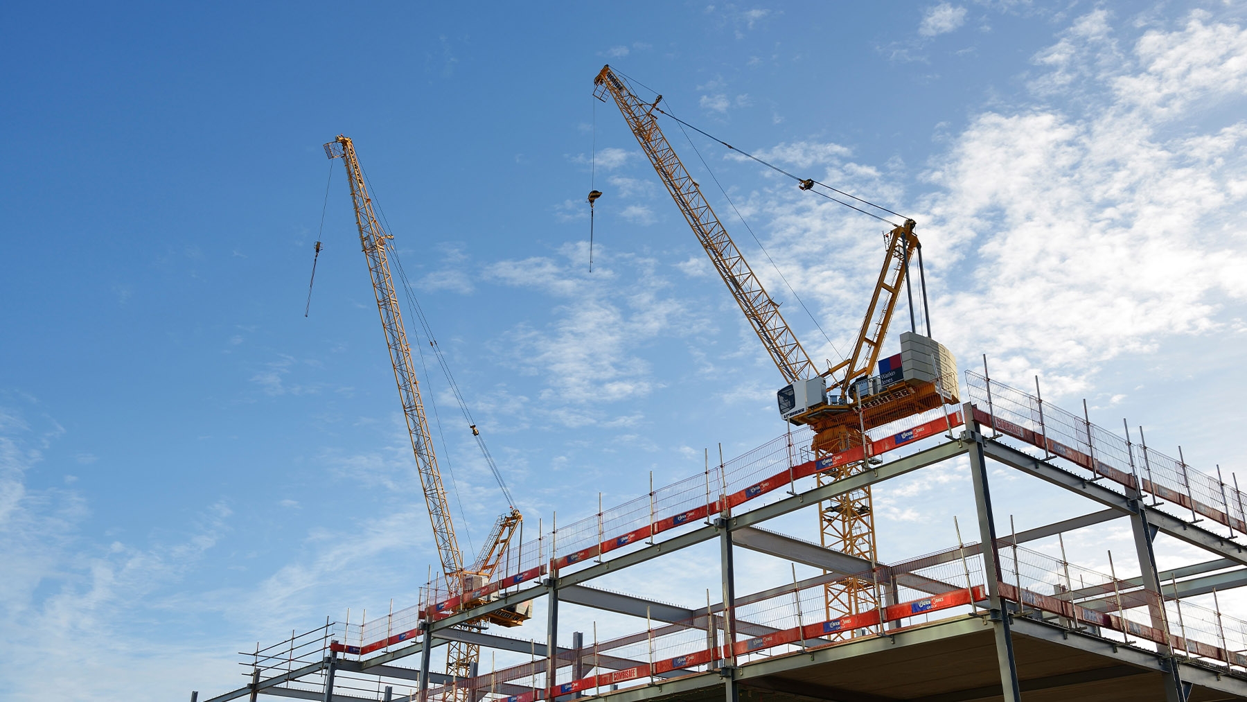 Steel frame and two cranes on a data center construction site 