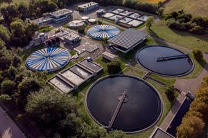 Water treatment facility in The Netherlands seen from above with various water tanks and adjacent buildings.