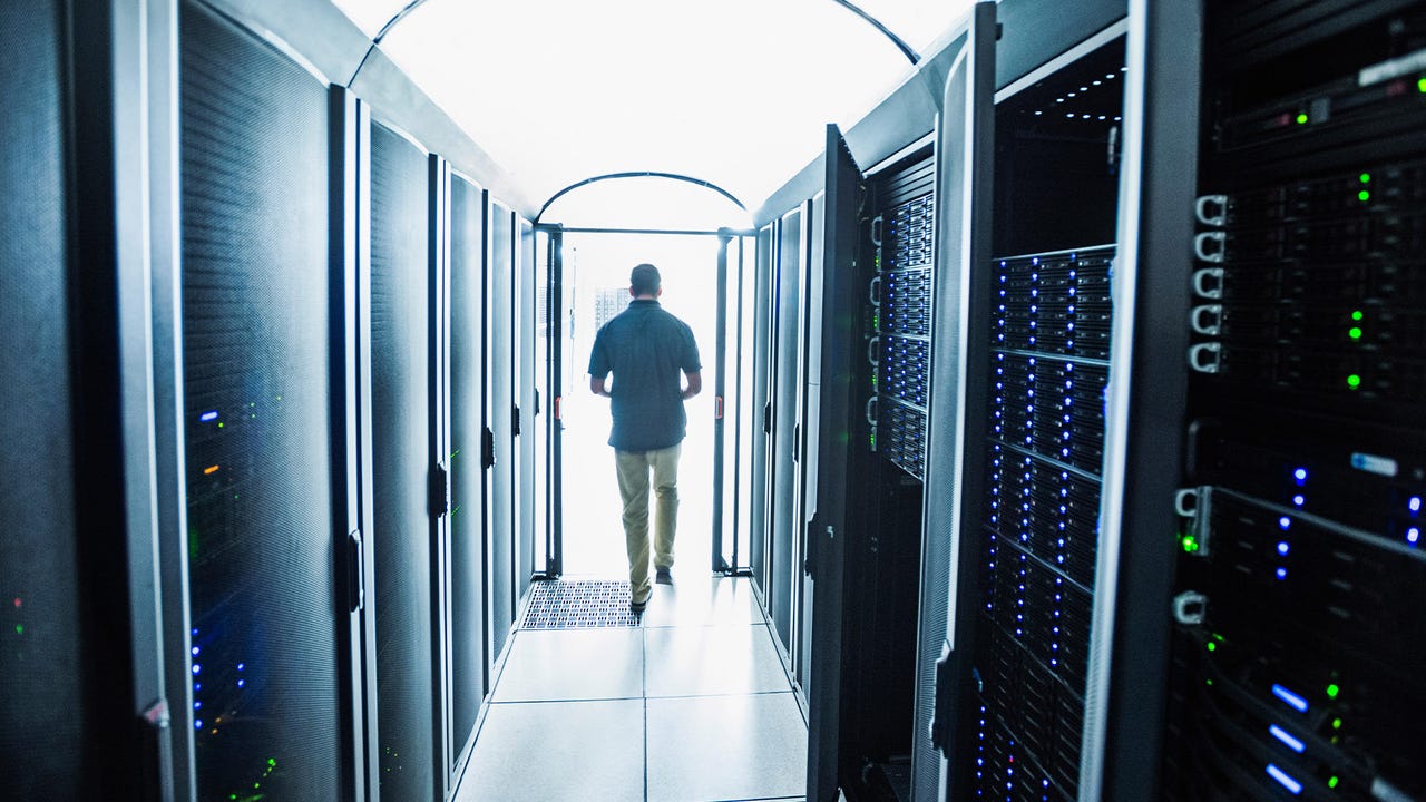 Data center technician in a server room Data center technician in a server room