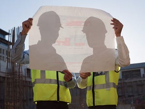 two men hold blueprints at data center construction site two men hold blueprints at data center construction site