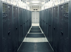 Photo of gray data center cabinets and hallway.