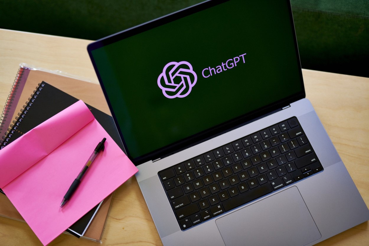 OpenAI logo on laptop with notebooks nearby OpenAI logo on laptop with notebooks nearby
