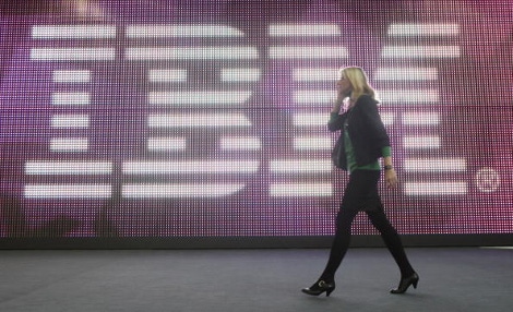 A young woman walks past the IBM logo at the 2009 CeBIT technology trade fair in Hanover, Germany.