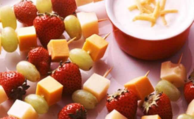 Plate filled with fruit skewers and dipping sauce