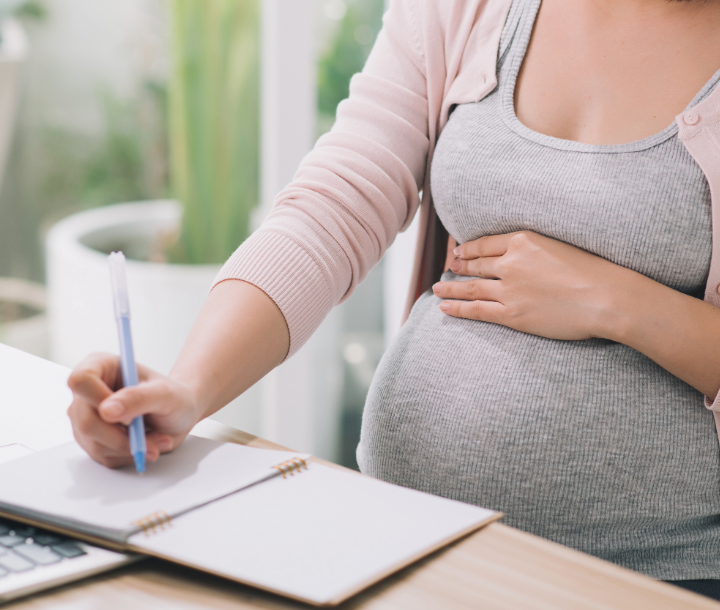 Mujer embarazada aprendiendo sobre nutrición durante el embarazo y cuidado prenatal para un embarazo saludable.