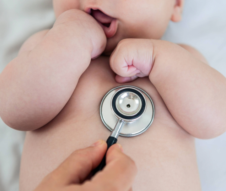 Pediatra utilizando estetoscopio para revisar a un bebé, representando las preguntas frecuentes en la consulta pediátrica.