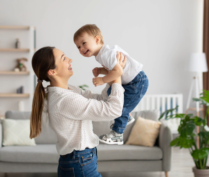 Madre con su hija pequeña al aire libre reforzando la importancia de continuar con la lactancia materna.