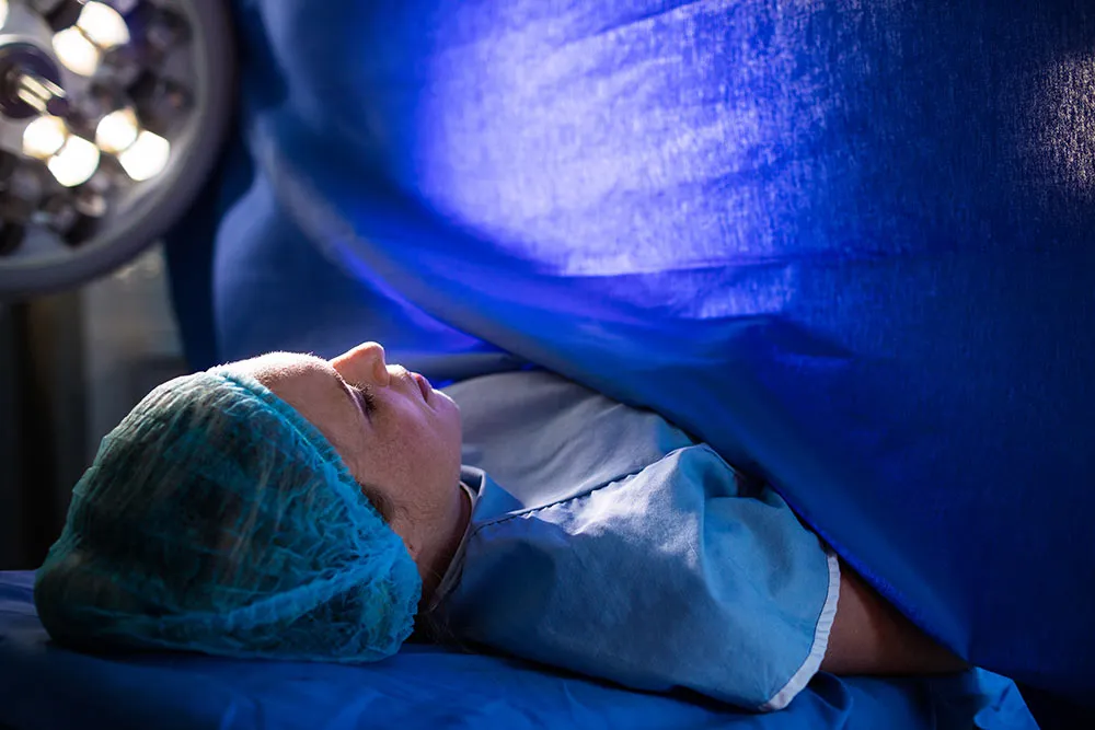 Pregnant woman prepared for C-section surgery in operating room