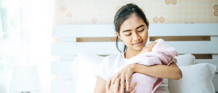 Newborn baby sleeping in the embrace of the mother 