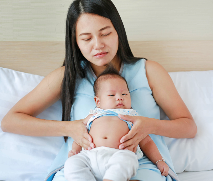 Bebé acostado boca arriba mientras un adulto le sostiene el abdomen, acompañado de texto sobre los mitos y realidades del reflujo infantil.