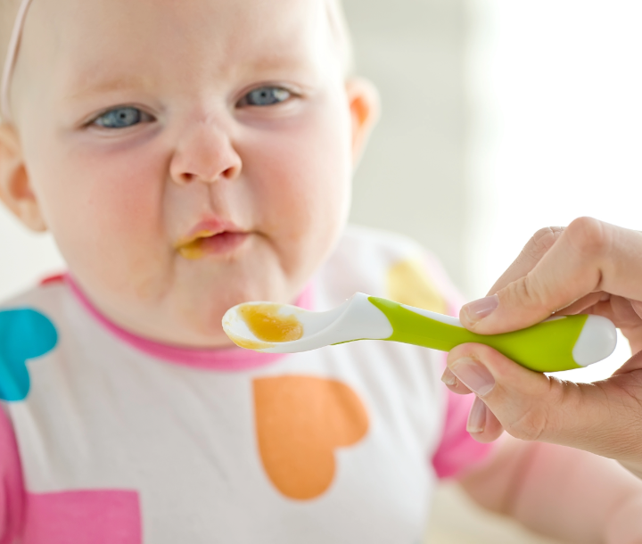 Bebé mostrando desagrado mientras es alimentado con cuchara, acompañado de texto sobre cómo atender los problemas más comunes en la infancia.