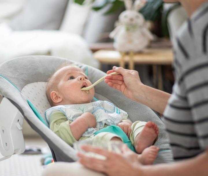 Madre alimentando a su bebé en el parque, destacando consejos para una alimentación infantil saludable.