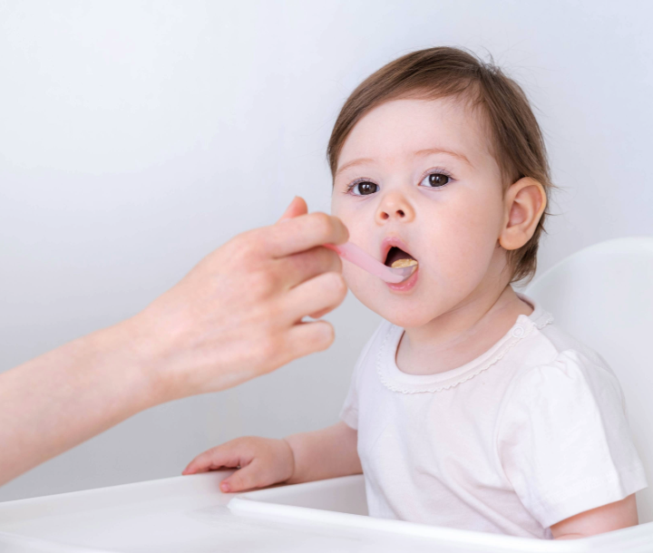 Alimentos ricos en vitamina D como salmón, huevos y verduras, junto a pizarra con el texto “Vitamina D”, relacionados con la importancia de este nutriente en la alimentación de los bebés.