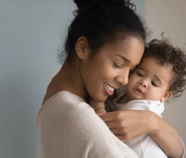 Bebé de cinco meses acostado boca abajo sobre una cama, acompañado de texto sobre el mundo y desarrollo en esta etapa de crecimiento.