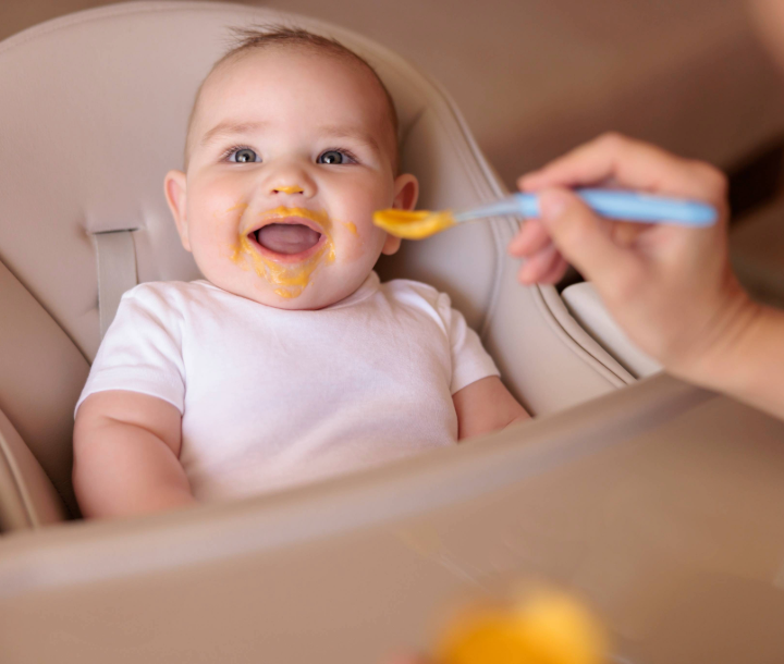 Bebé sonriente mordiendo un juguete, junto a texto de guía de alimentación infantil con consejos sobre nutrientes esenciales.