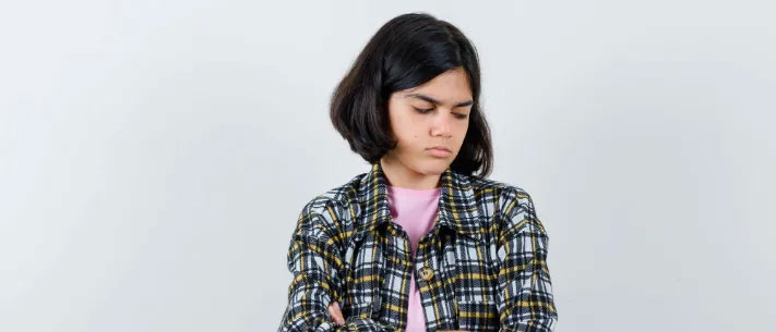 Young girl holding stomach with uncomfortable expression showing signs of digestive discomfort
