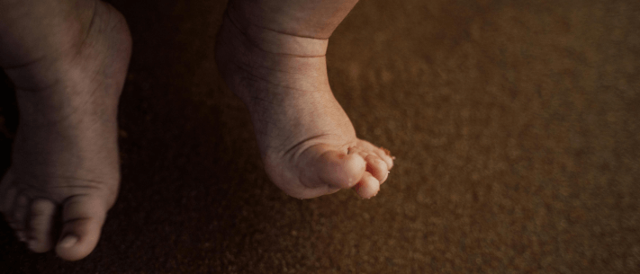 Baby's Feet Against Brown Background