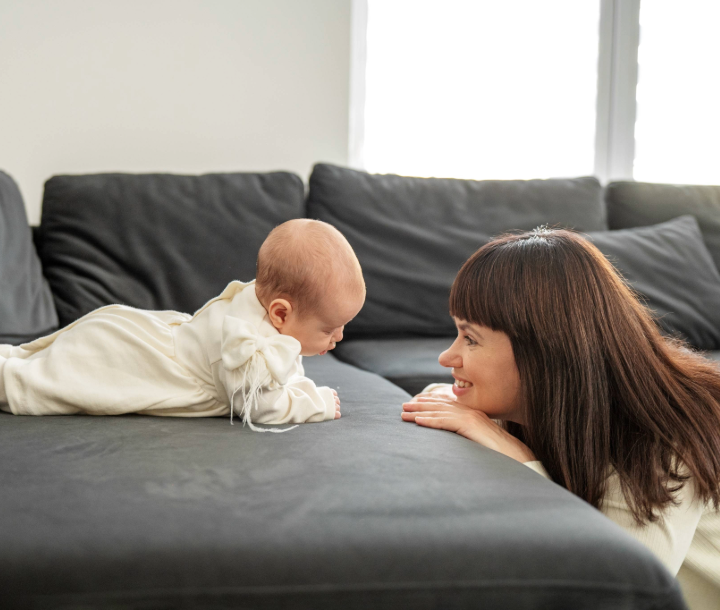Mujer trabajando en casa con su bebé cerca, mostrando el regreso a la rutina laboral tras la licencia de maternidad.