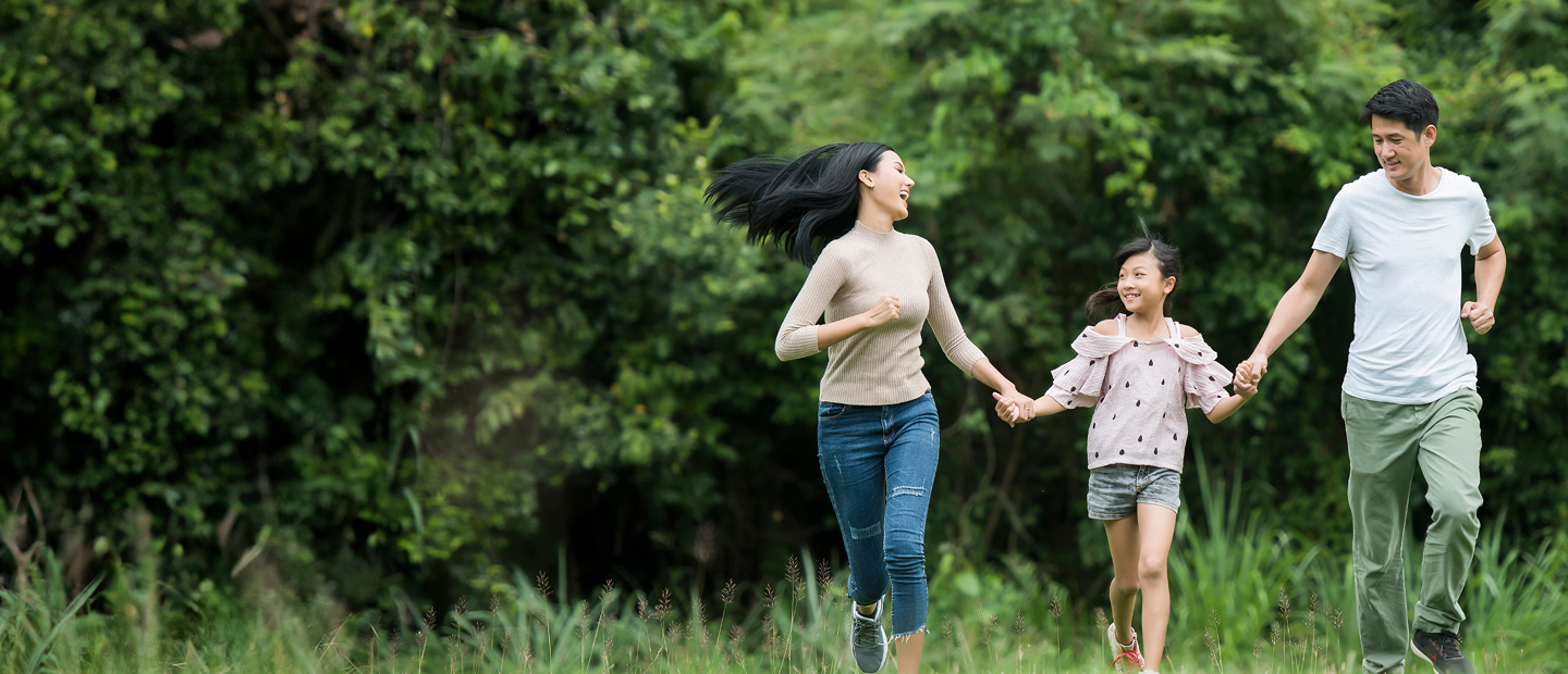 Joyful Family Holding Hands While Running Outdoors