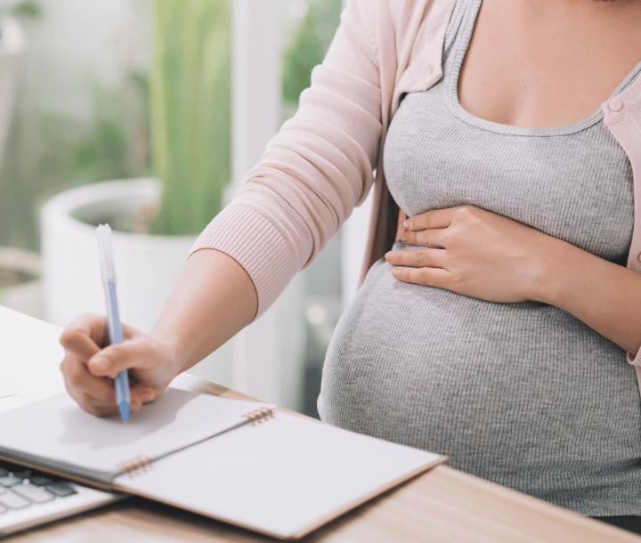 Mujer embarazada aprendiendo sobre nutrición durante el embarazo y cuidado prenatal para un embarazo saludable.
