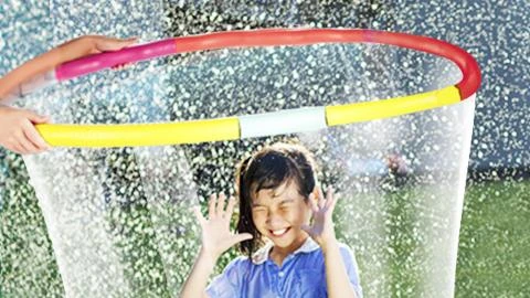 Young girl smiling inside a bubble made from hula-hoop