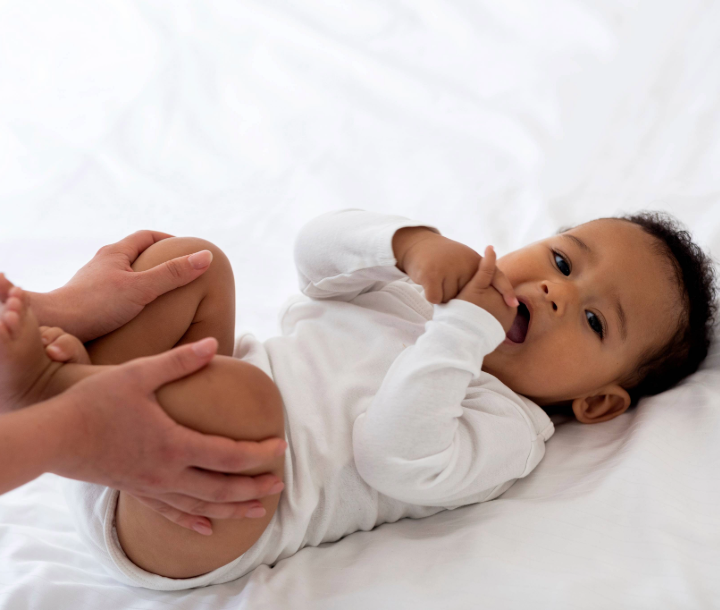 Bebé acostado mientras un adulto le masajea el abdomen, acompañado de texto sobre seis consejos para aliviar los gases en bebés.
